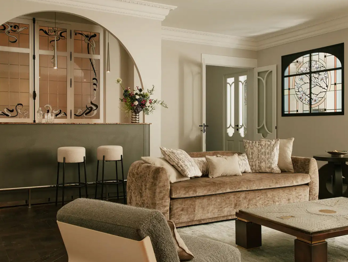 Salon avec arche, canapé en velours et vitraux